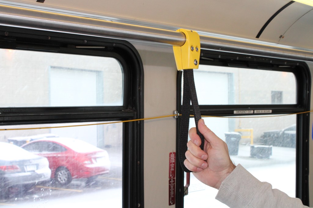 Bus Strap, passenger assist handle. To show a person holding a grab strap in a bus.